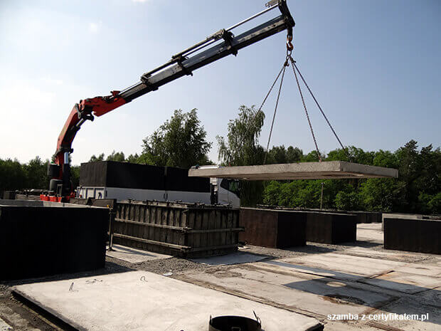 Załadunek szczelnego szamba betonowego do transportu  w Jasieniu